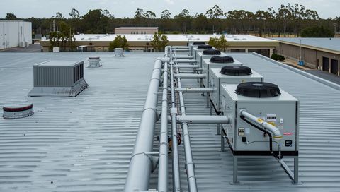 Row of rooftop plant units and pipework on a data centre roof